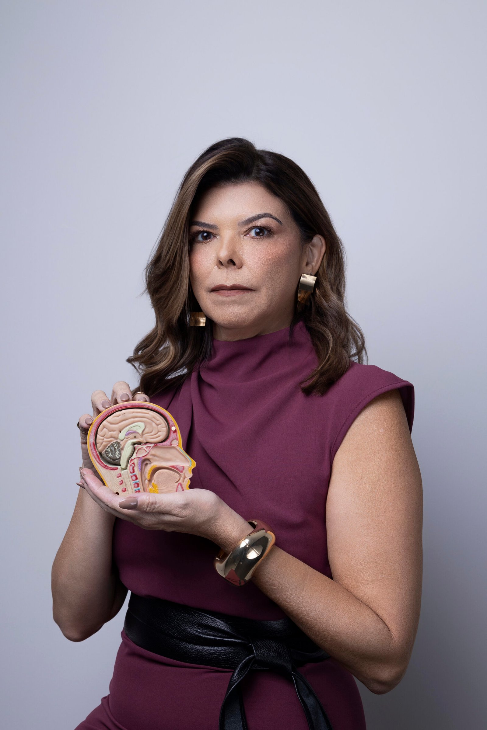 Dra. Silvia Andrade segurando um modelo anatômico do cérebro